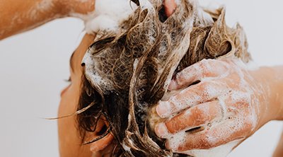 mujer lavándose el pelo
